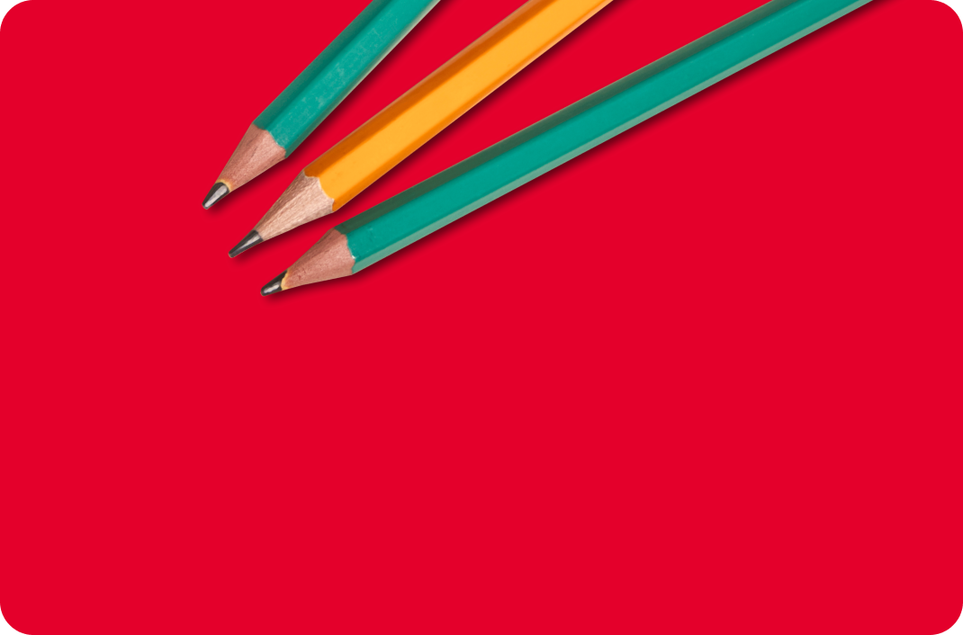 Three pencils on a red surface.